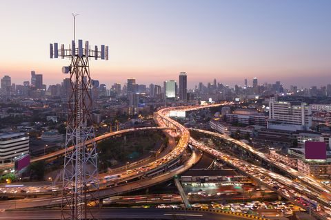 Telecommunication tower with 5G cellular network antenna on city background