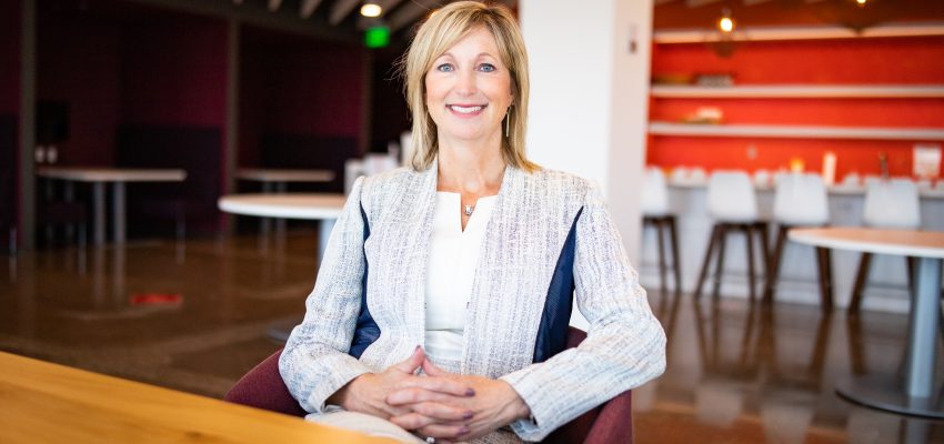 A photo of Lynnette Heath sitting at the nVent office and smiling at the camera